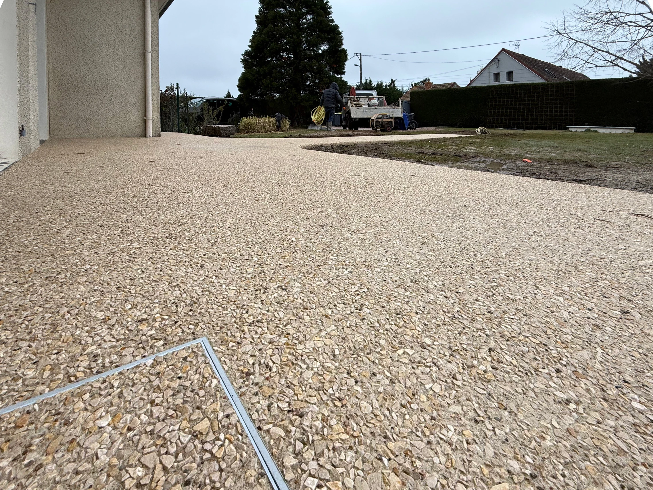 Terrasse en béton désactivé beige devant une maison, réalisée par BâtiTravaux près de Vichy