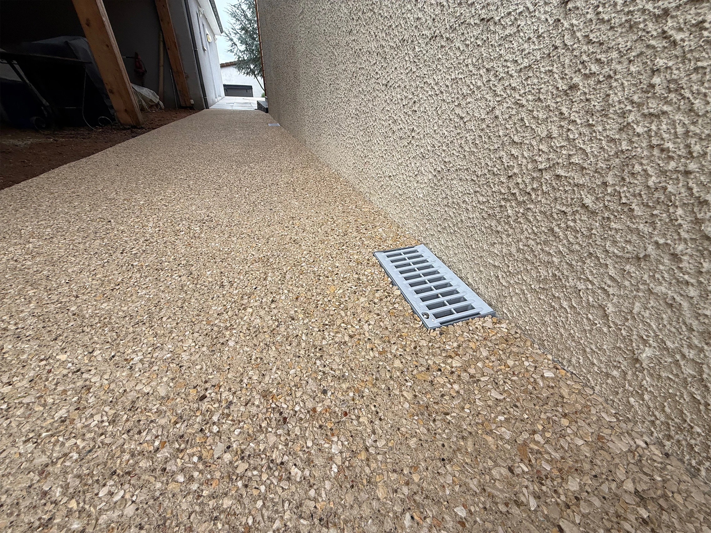 Détail d'un caniveau intégré dans une terrasse en béton désactivé
