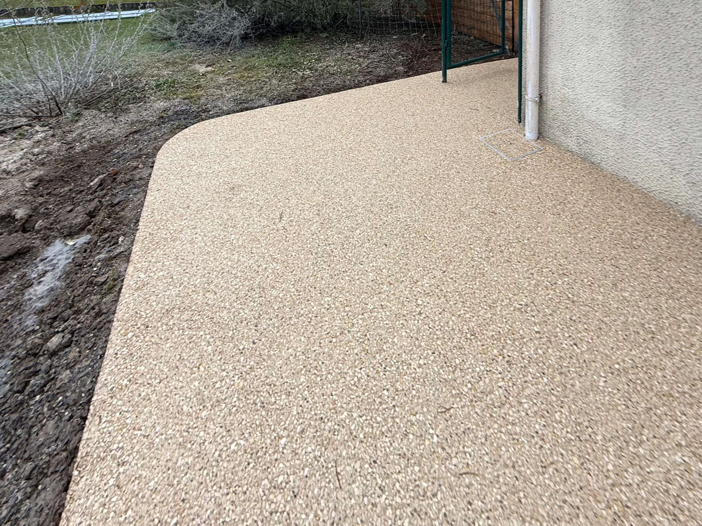 Angle de terrasse en béton désactivé avec bordure paysagère
