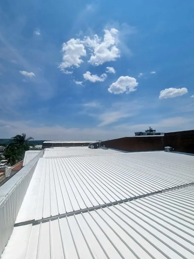 Cool roofing à Vichy : peinture réflective blanche sur toiture industrielle en bac acier