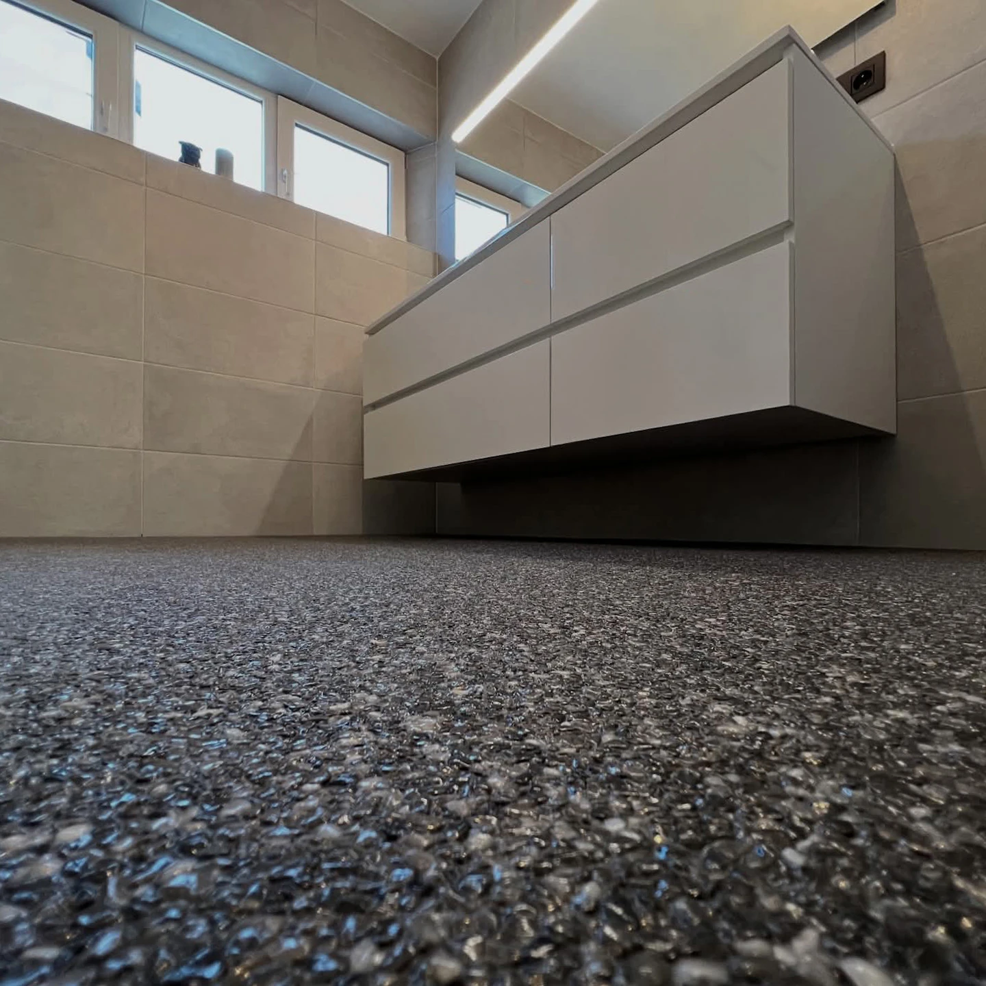 Salle de bain rénovée avec sol en moquette de pierre antidérapante